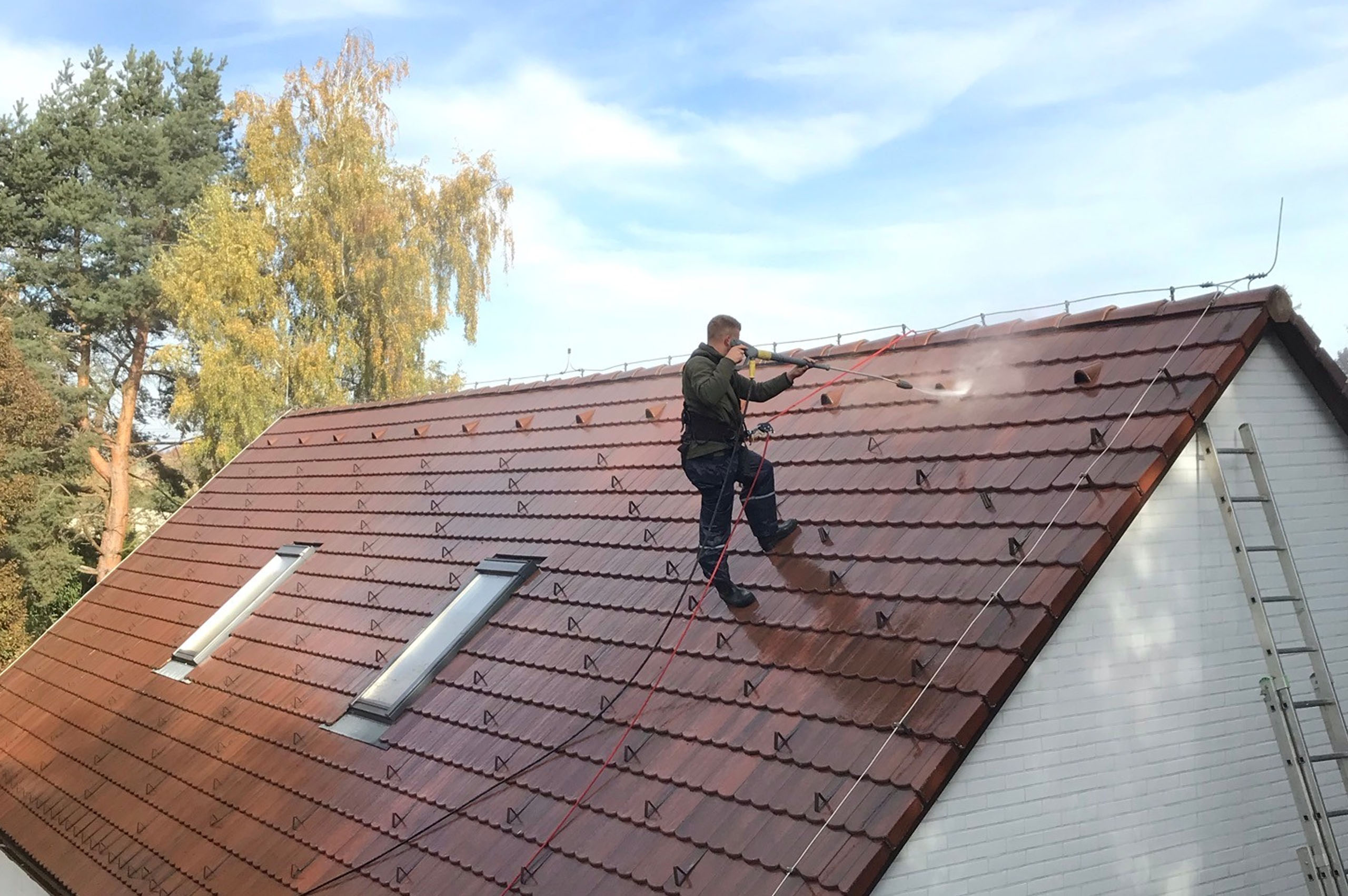 Pracovník čístící střechu