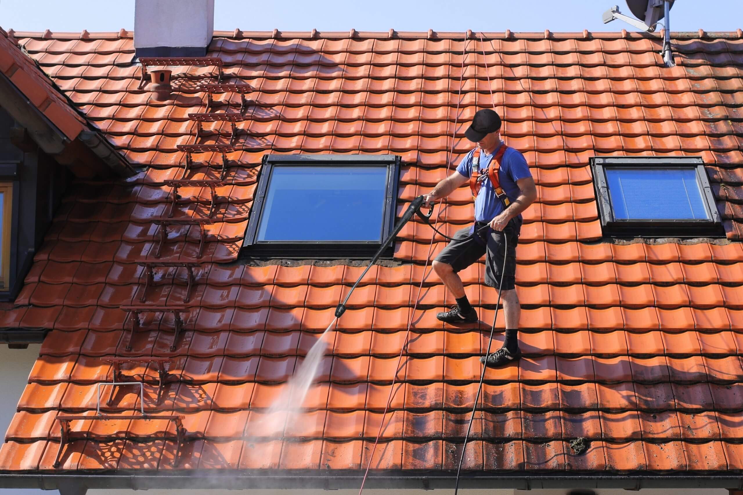 Pracovník čístící střechu